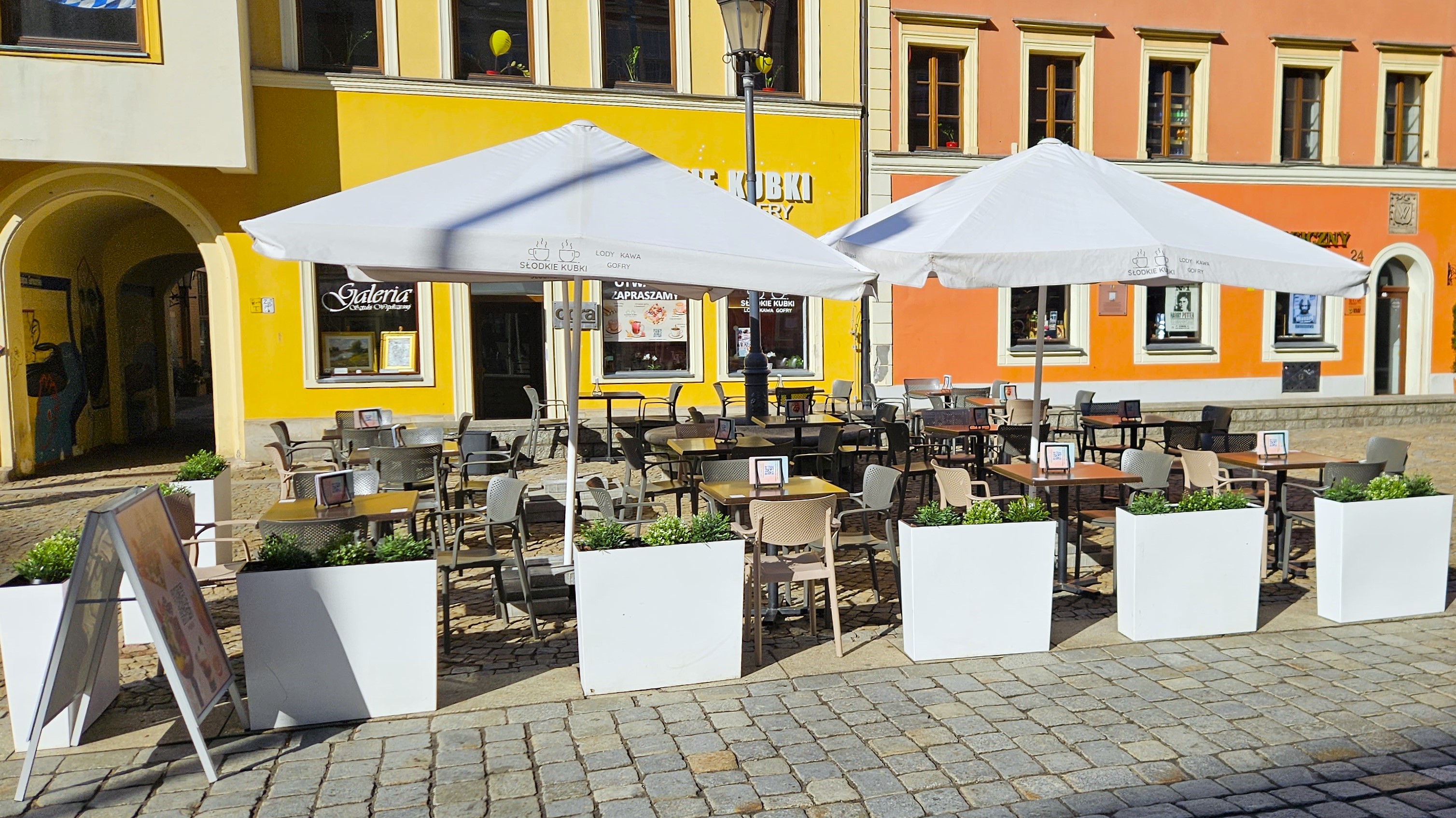 Duży ogródek gastronomiczny przed kawiarnią Słodkie Kubki